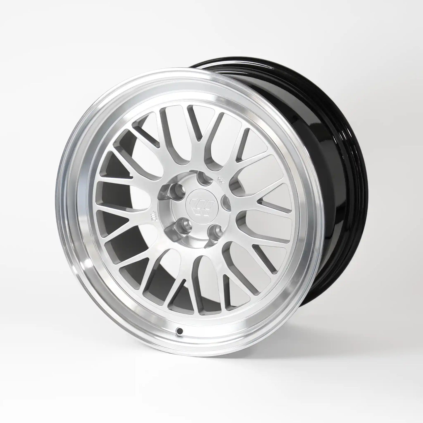 A multi-spoke alloy wheel rim with a polished silver face and a glossy black rear lip, shown on a clean white studio background.