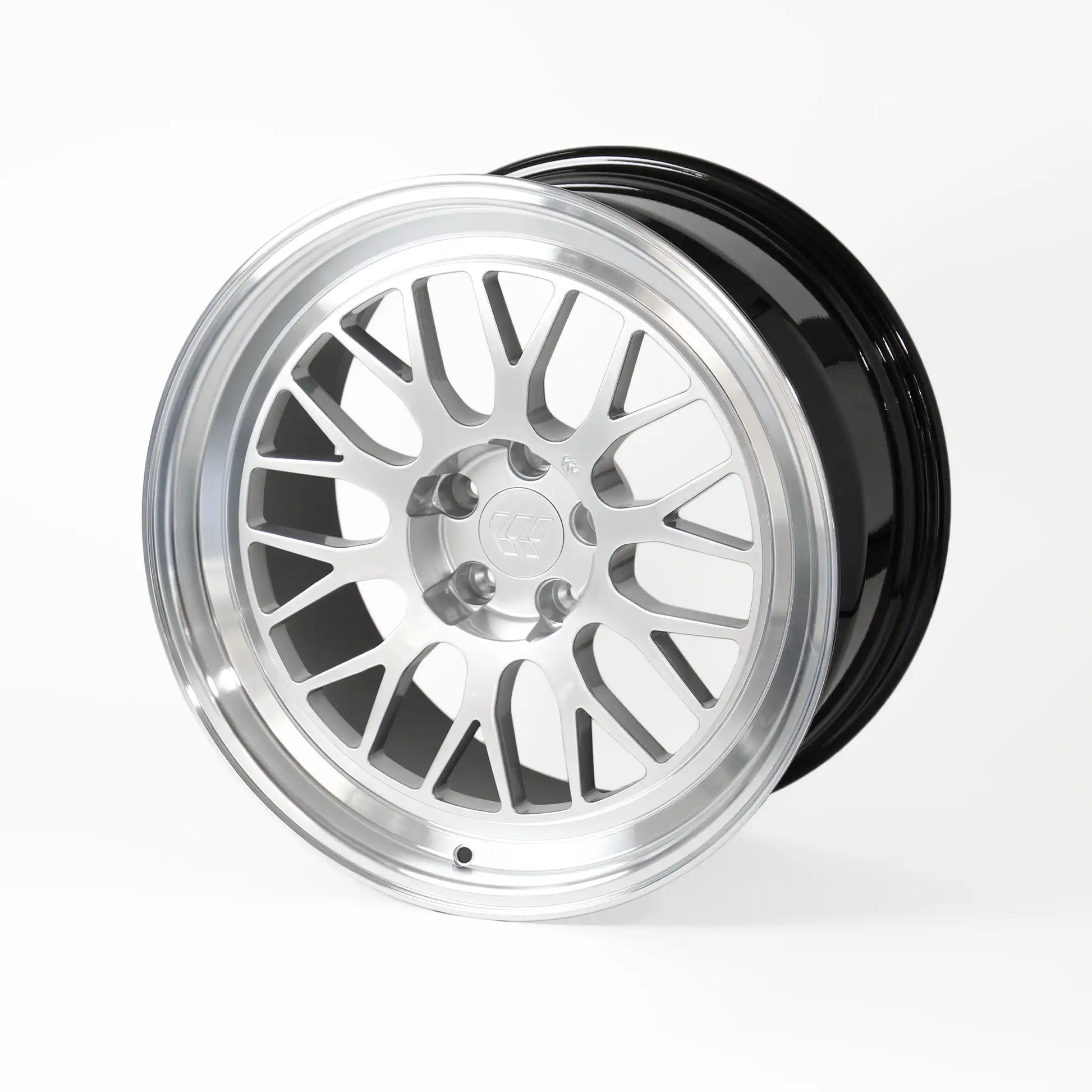 A multi-spoke alloy wheel rim with a polished silver finish and a glossy black outer barrel, shown on a light gray studio background.