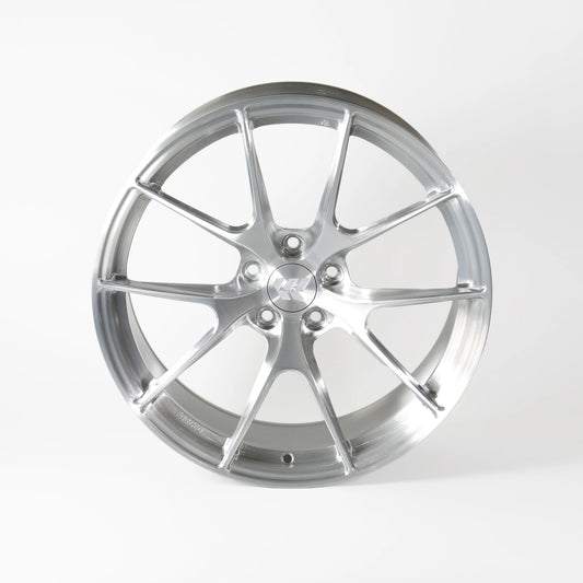A polished silver multi-spoke alloy wheel rim, photographed from a front-three-quarter angle on a clean white studio background.