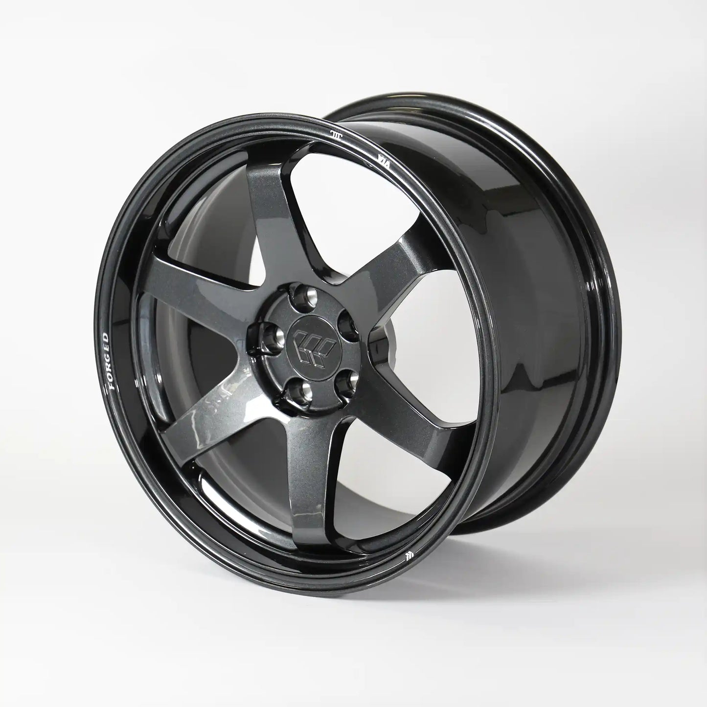 A glossy black multi-spoke alloy wheel rim, photographed at a three-quarter angle on a clean white studio background.