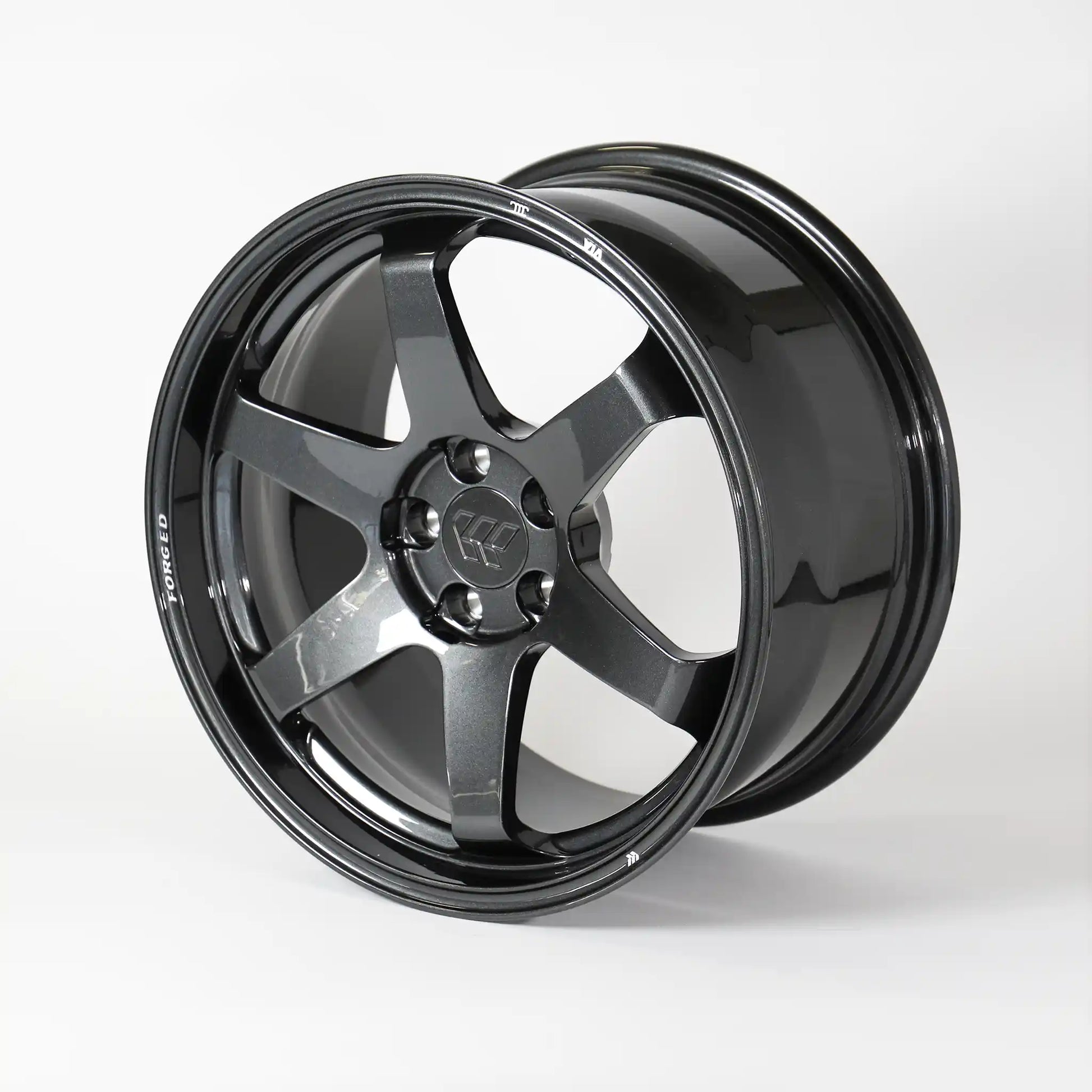 A glossy black multi-spoke alloy wheel rim, photographed at a three-quarter angle on a clean white studio background.