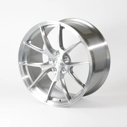 A polished silver alloy wheel rim with a multi-spoke design, photographed on a seamless light gray studio background.